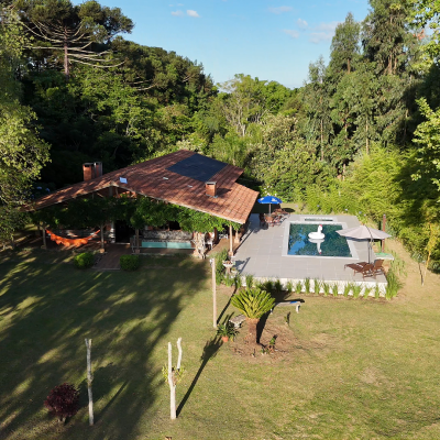 Vista aérea do sítio com piscina e área verde — privacidade e conforto
