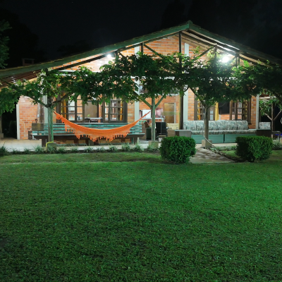 Casa principal com varanda e rede — mistura de conforto e natureza