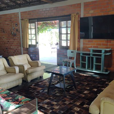 Sala de estar ampla com sofás confortáveis e TV — ideal para curtir em grupo