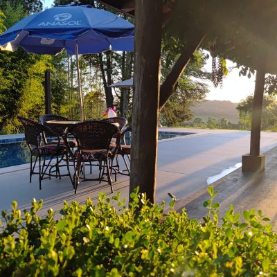 Espaço gourmet com mesa externa e guarda-sol — lazer garantido ao ar livre