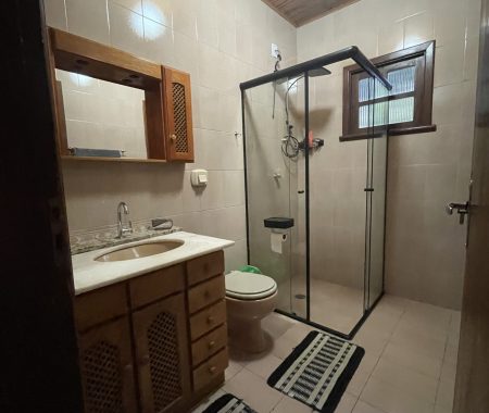 Banheiro completo com box de vidro e bancada espaçosa — funcionalidade e higiene garantida