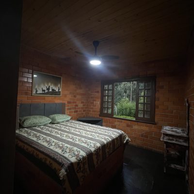 Suíte aconchegante com cama de casal e vista para o verde — conforto e privacidade