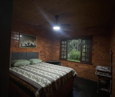 Suíte aconchegante com cama de casal e vista para o verde — conforto e privacidade