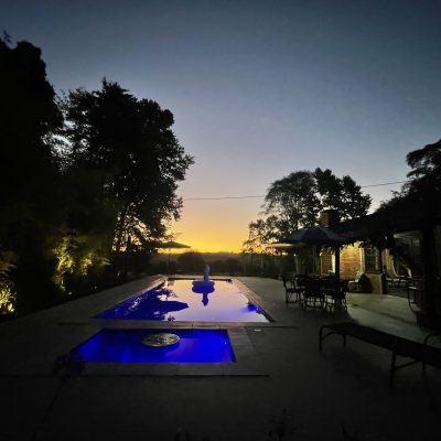 Piscina iluminada à noite com vista panorâmica — ambiente perfeito para um fim de dia inesquecível