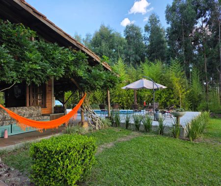 Área externa com rede e jardim — cenário perfeito para descansar e respirar natureza